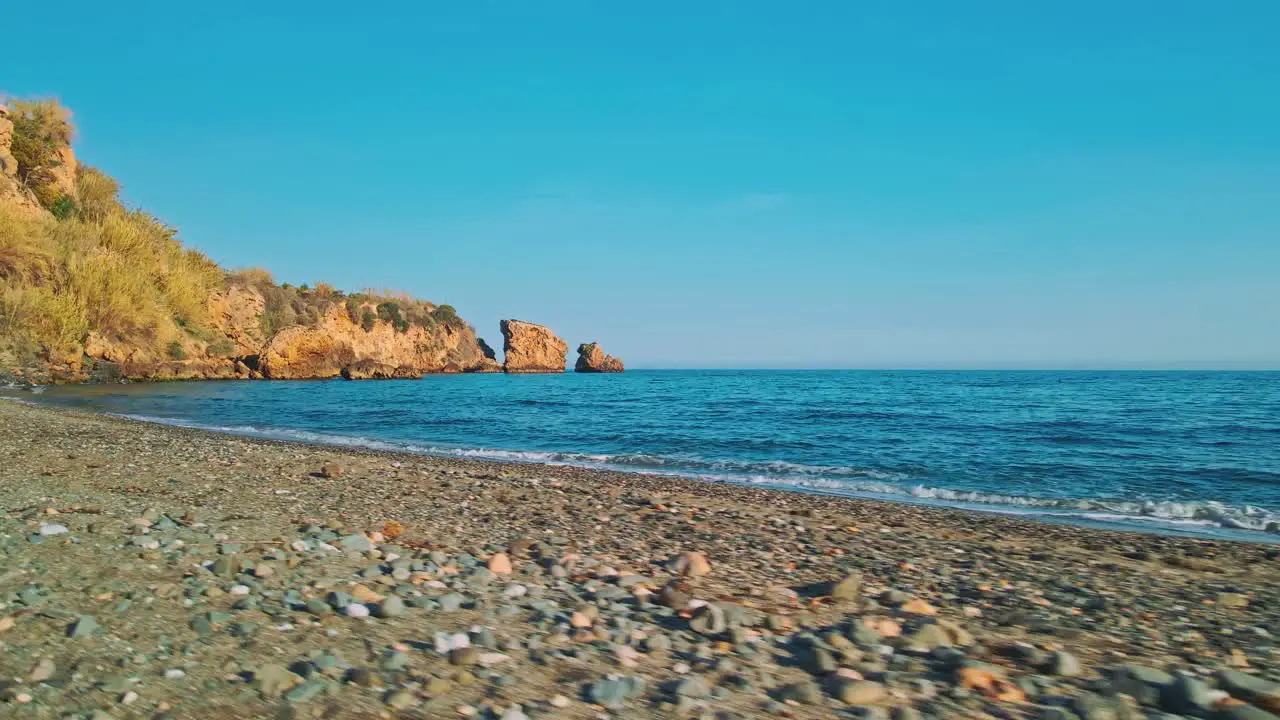 Empty rocky beach with drone moving into the sea