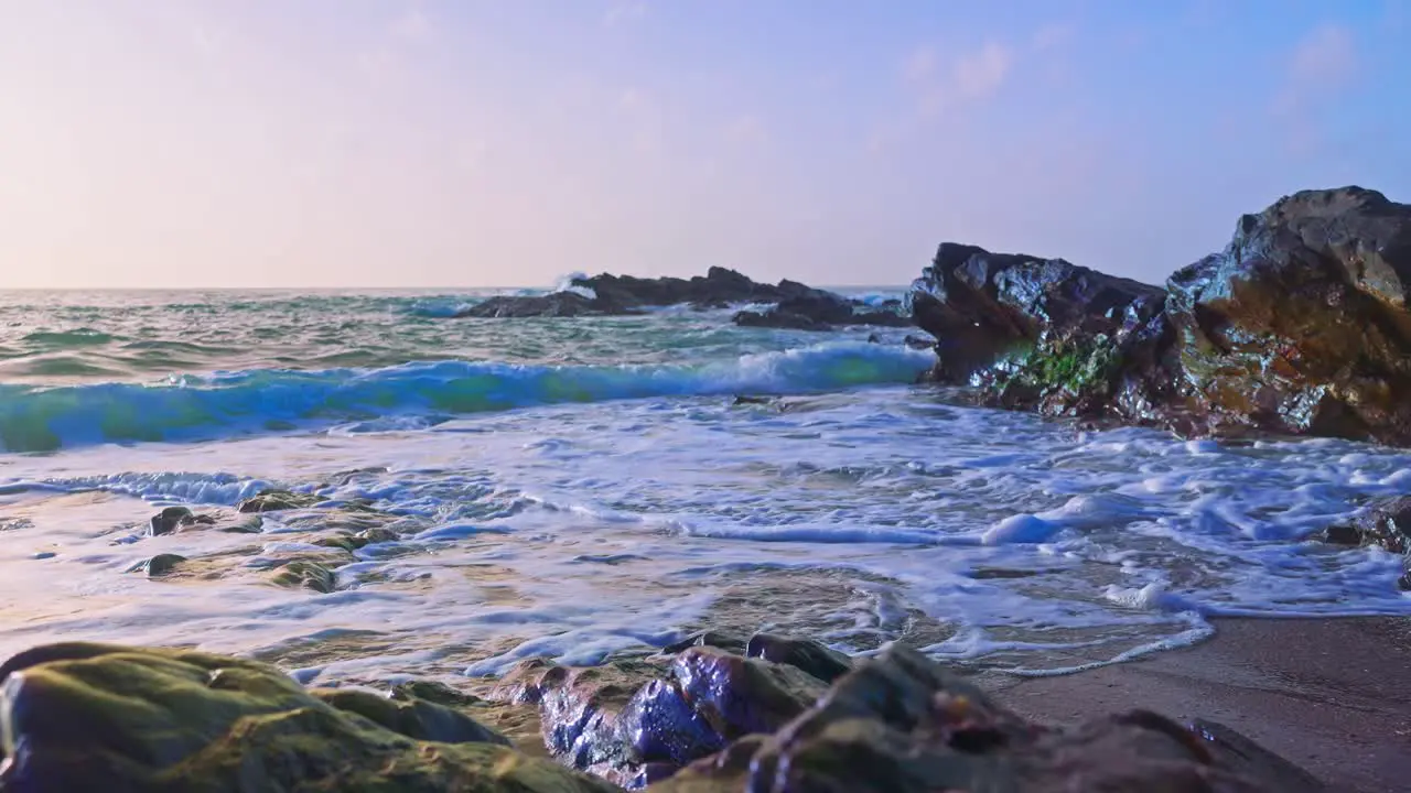 Ocean waves crashing on a sandy and rocky beach