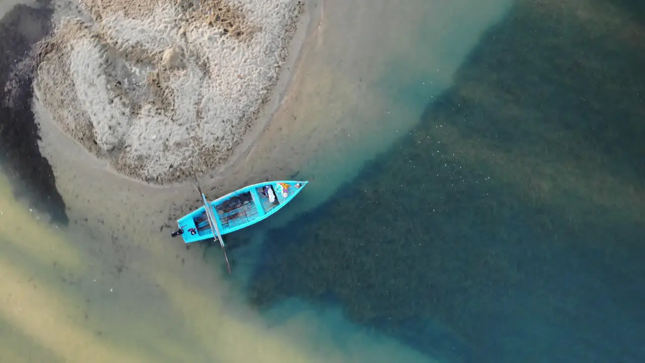 Wooden traditional small boat tied near sandy banks aerial view