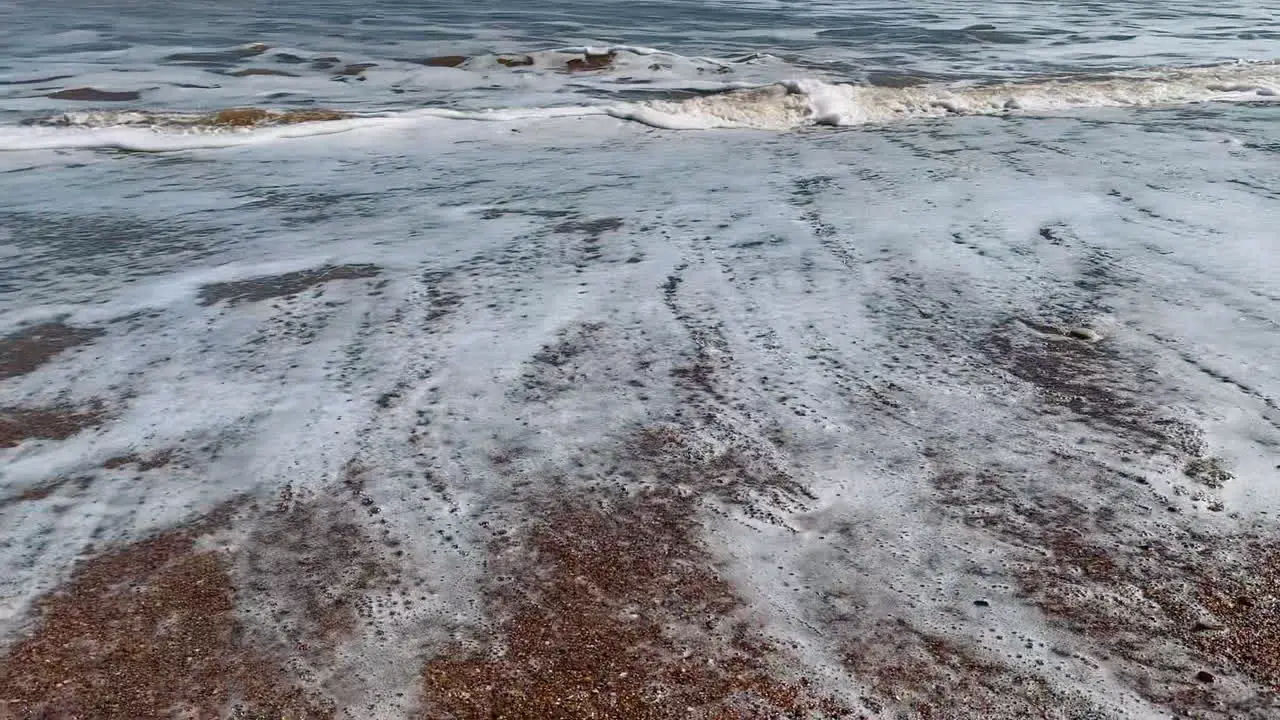 Footprints in the sand washed away by the sea waves at the coast