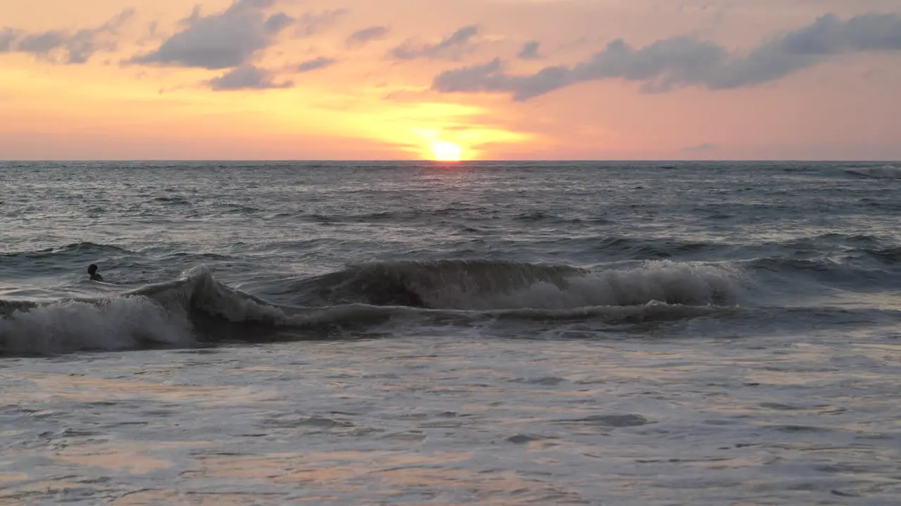 Silhouette of surfer bobbing up and down waiting for the right set of waves