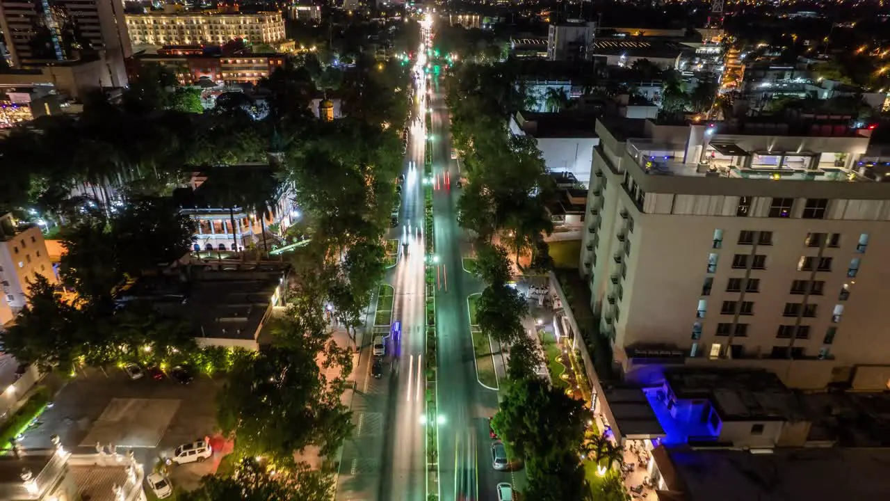 aerial nighttime photograph of a vibrant city boulevard alive with the warm glow of streetlights that trace a path through the urban landscape