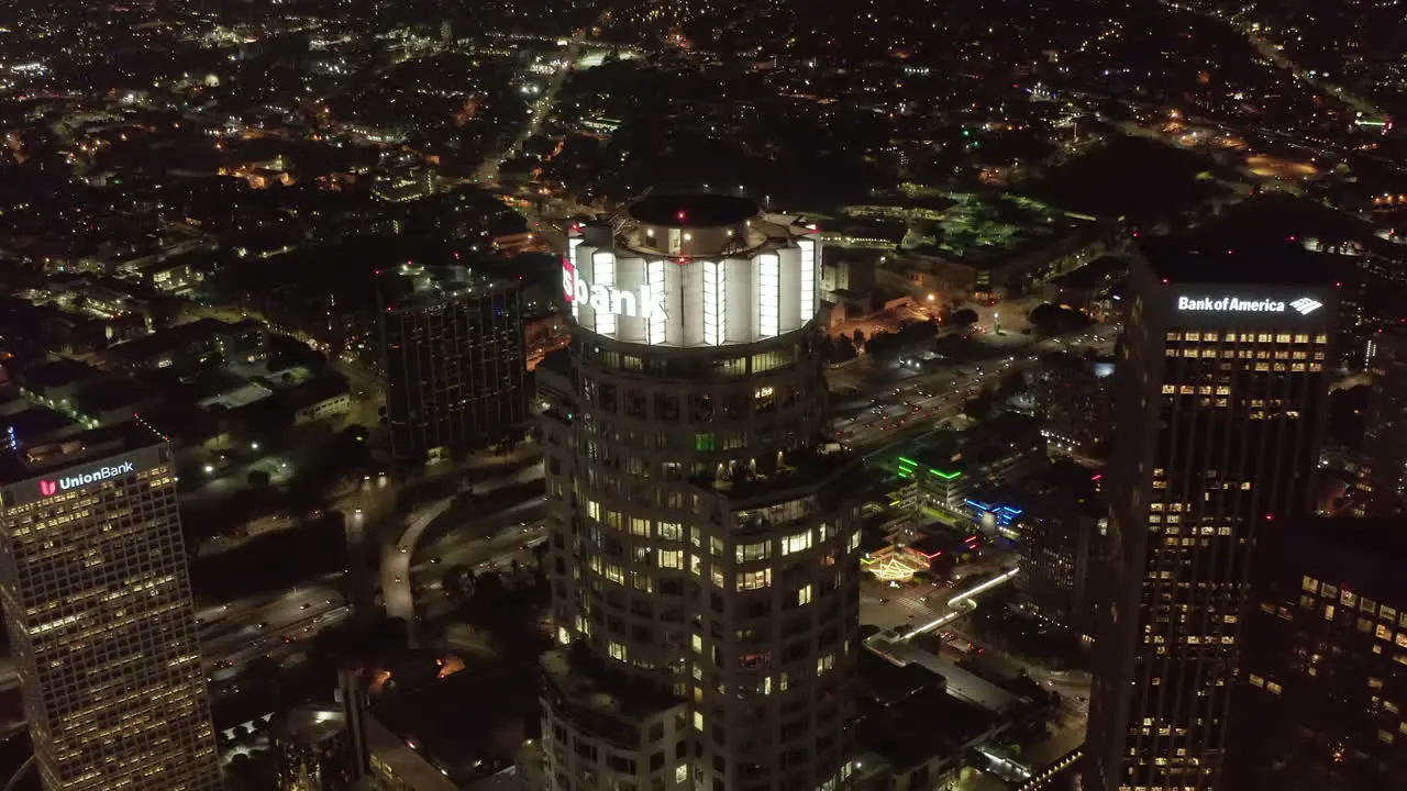 Scenic Wide View of Skyscrapers in Big City at Night with lit up illuminated Buildings in Los Angeles Skyline Aerial Drone rising shot Circa 2019