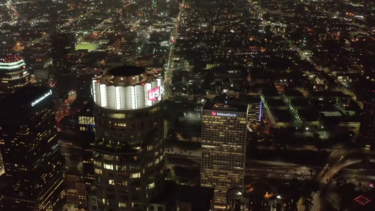 AERIAL Close up view of US Bank Tower skyscraper and Downtown Los Angeles California at Night glowing city lights Circa 2019