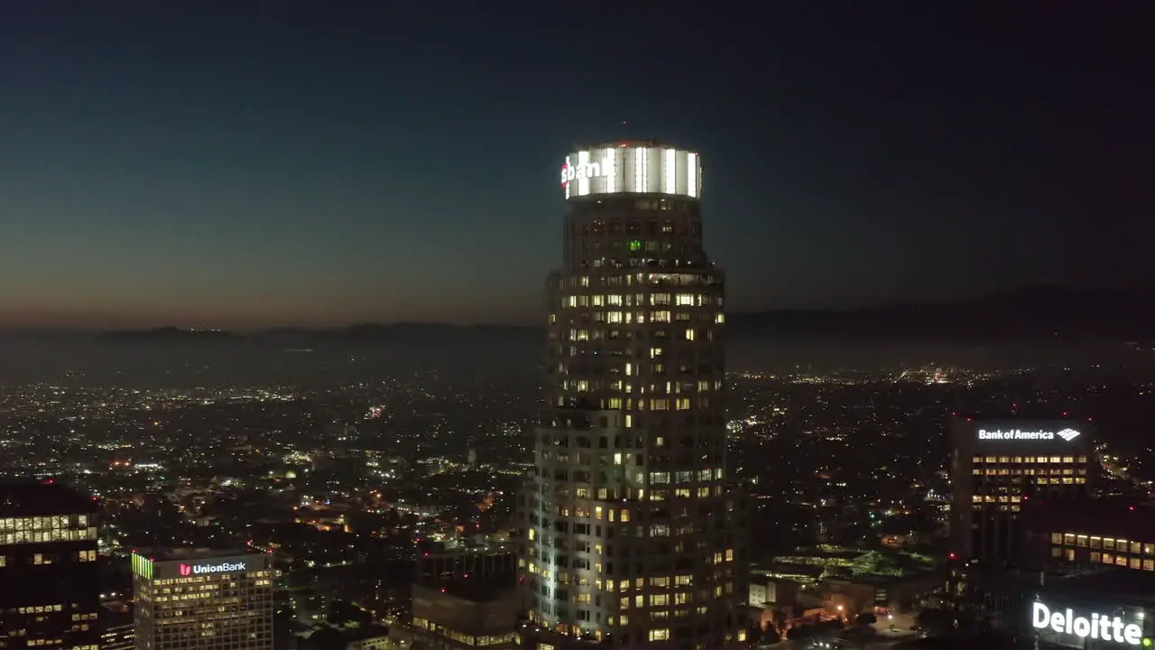 Famous Skyscraper US Bank Tower of Los Angeles Skyline with Rooftop View over the City at Night Aerial Drone Establishing Wide Shot Circa 2019