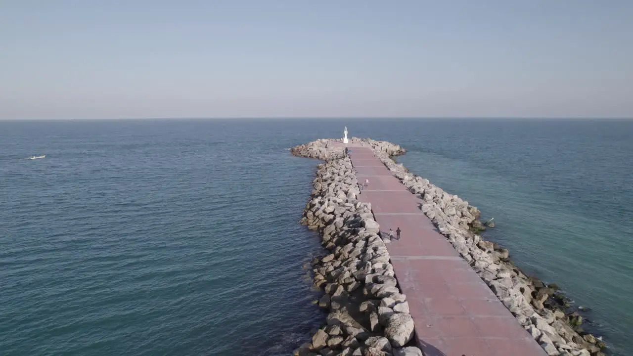 Aerial shot of people walking on the breakwater