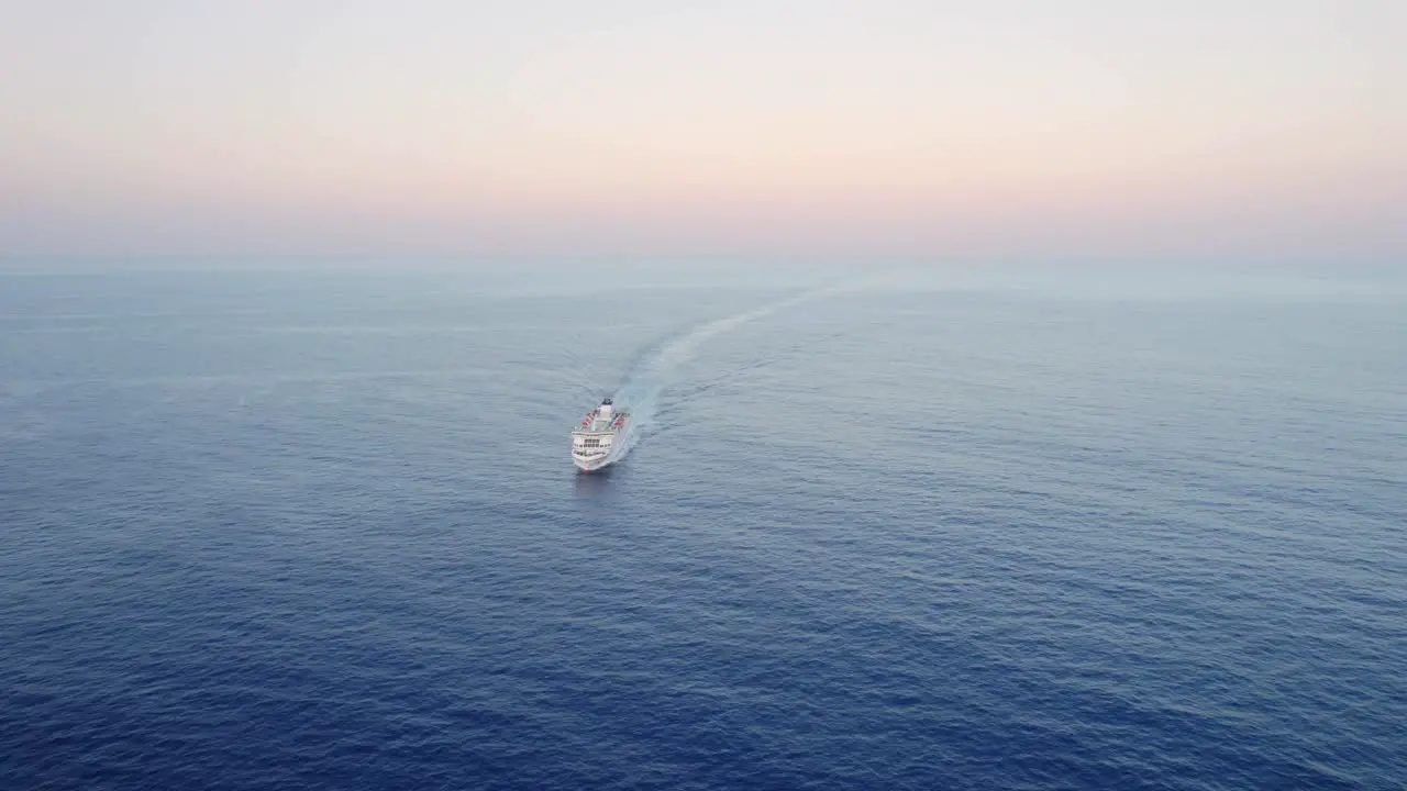 Large Roro Ferry ship sailing calm sea at dawn high angle front view drone aerial shot