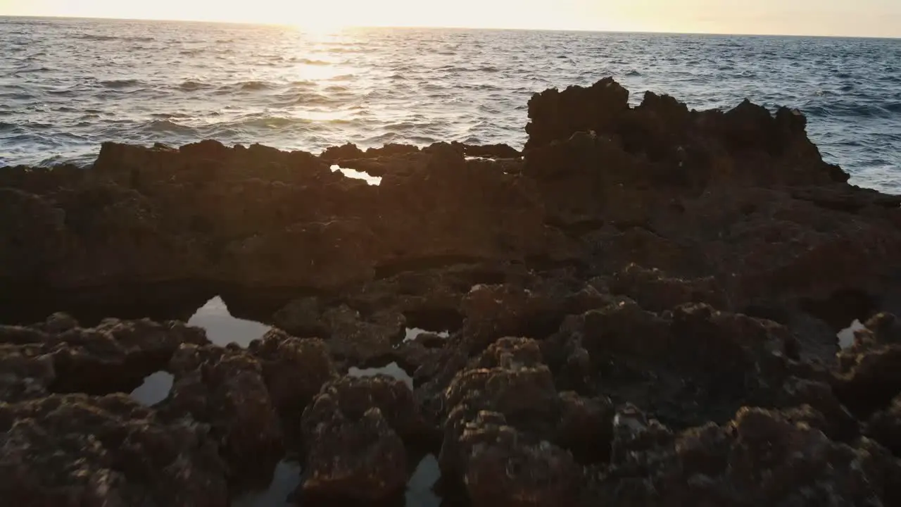 Low Flying Over Rock Pools And Out To Sea With Choppy Waves During Sunset At Cala Xarraca