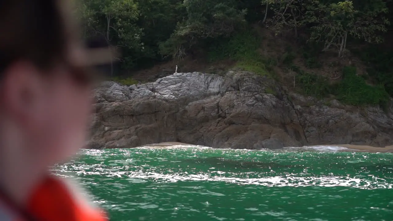 Sailing along the coast with amazing views of the shoreline and clear green ocean water in slow motion