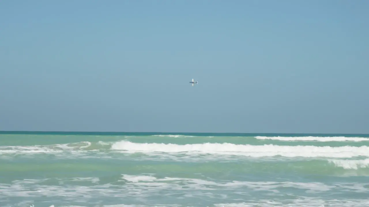 Propeller plane flying near the beach