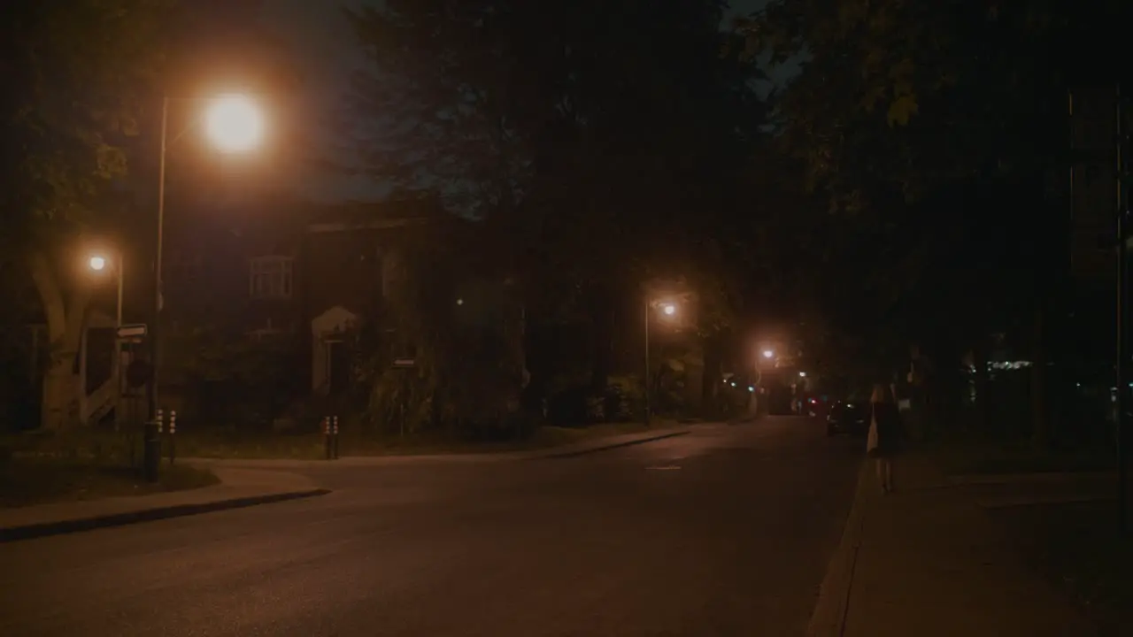 Lone Female Walking Down Empty Street Lit By Orange Street Lights In Montreal