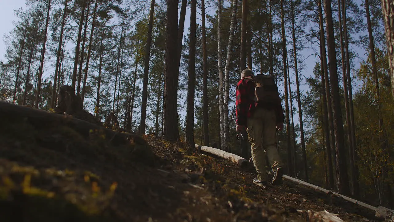 Un Hombre De Mediana Edad Está Caminando Solo En El Bosque Llevando Una Mochila Y Una Caña De Pescar Haciendo Caminatas Y Mochileros