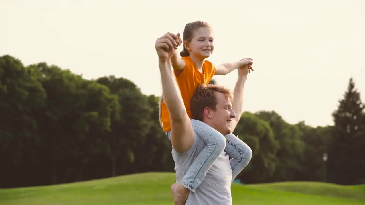 Padre Alegre Cargando A Su Hija Feliz Sobre Los Hombros Y Dando Vueltas En Un Parque