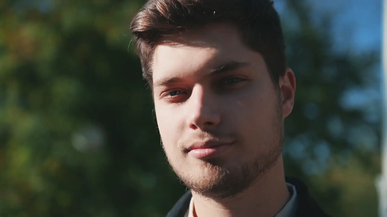 Retrato De Un Joven Apuesto Sonriendo Y Mirando A La Cámara Al Aire Libre