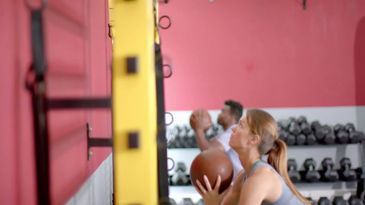 Fit focused gym-goers engage in a workout session with medicine balls