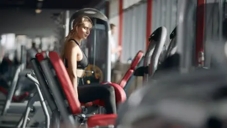 Beautiful woman doing fitness exercise on sport simulator in gym club