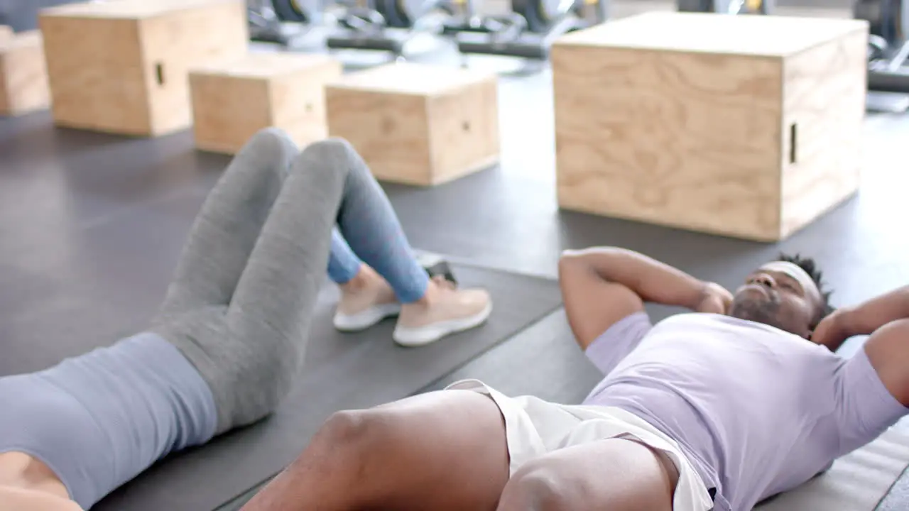 Fit diverse couple rests after a workout at the gym