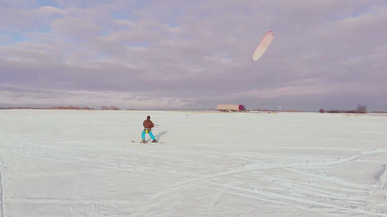 Kite surfer being pulled by his kite across the snow