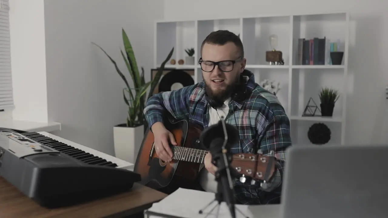 Male Musician Recording And Streaming A Video Playing Guitar At Home