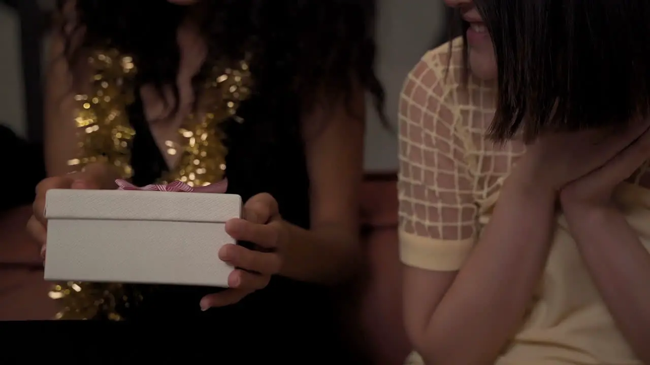 Young Woman Gives A Gift Box With Bow To Her Black Female Friend