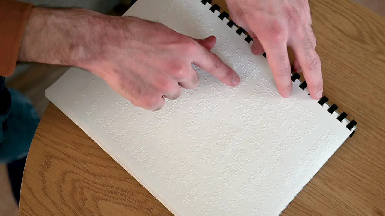 Top View Of An Unrecognizable Man Reading A Braille Book At Home