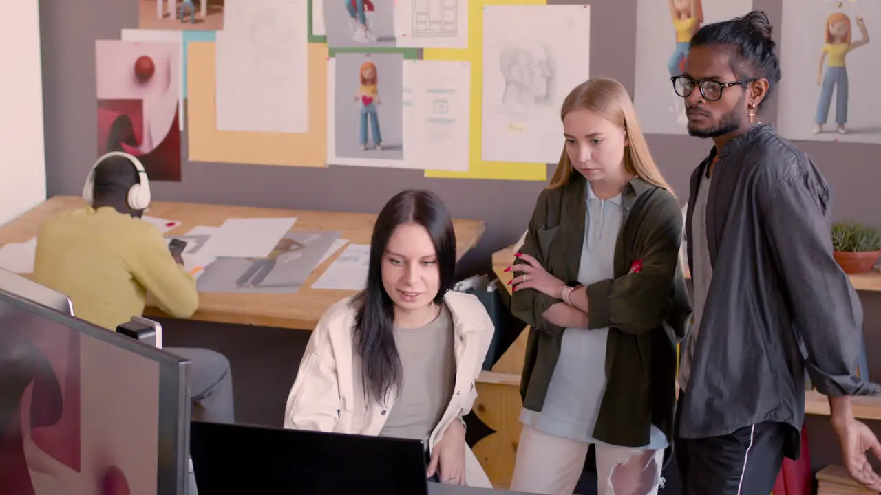 Young Female Graphic Designer Explaining Project On Computer To Her Multiethnic Colleagues In An Animation Studio 1