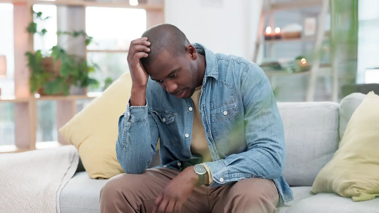 Mistake anxiety and sad black man on sofa