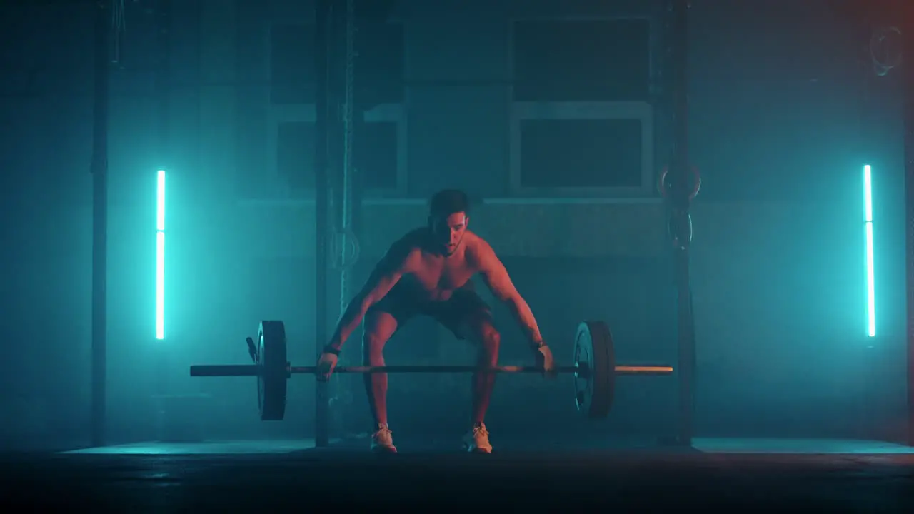 Athletic Shirtless Man Training Doing Power Strength and Endurance Exercises with Barbell Workout in the Hardcore Gym in slow motion