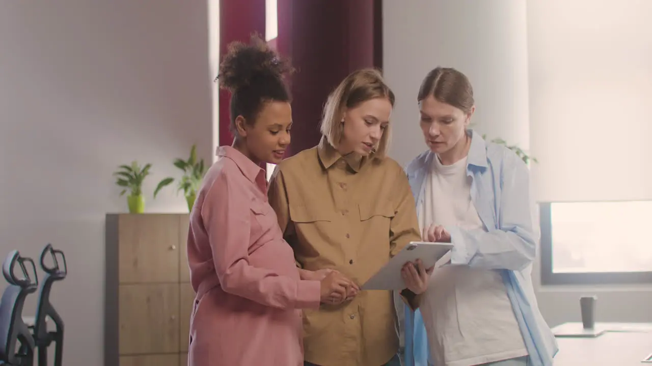 Three Pregnant Woman Looking At Tablet And Talking In The Office