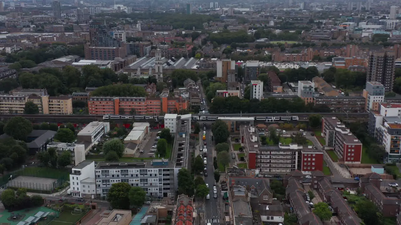 Forwards fly above urban neighbourhood with rail track Passenger train driving through footage London UK