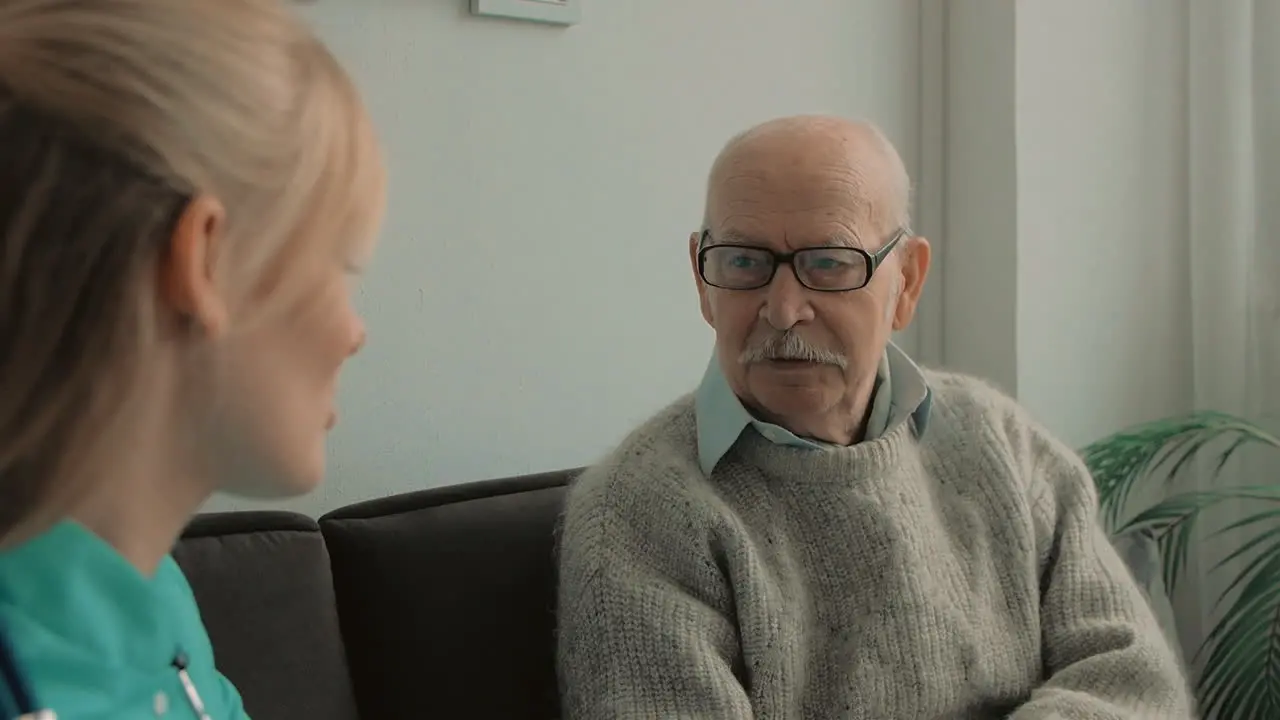 Elderly Man Talking With Young Caring Nurse