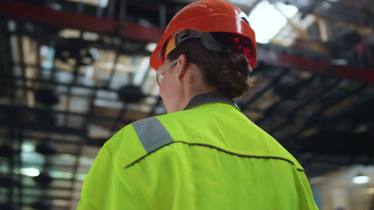 Joyful woman supervisor smiling at huge digital modern production warehouse