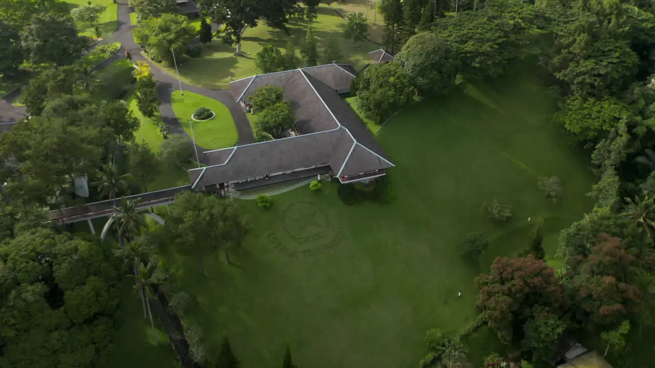 Close up aerial view circling around the official seal on the grass in front of the Tampaksiring Presidential Palace in Bali