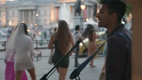 Busker With Guitar Playing To Tourists In Trafalgar Square In London England UK