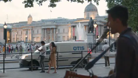 Busker With Guitar Playing To Tourists In Trafalgar Square In London England UK 2