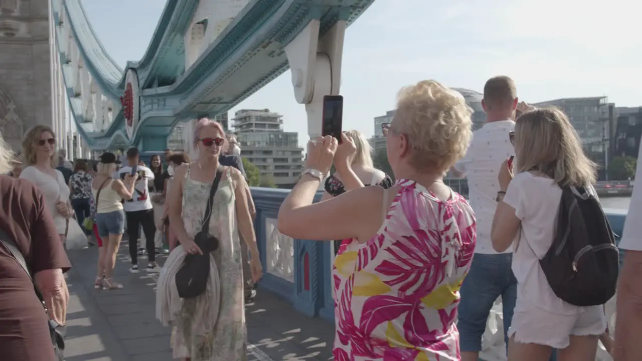 Summer Tourists Walking Across Tower Bridge London England UK