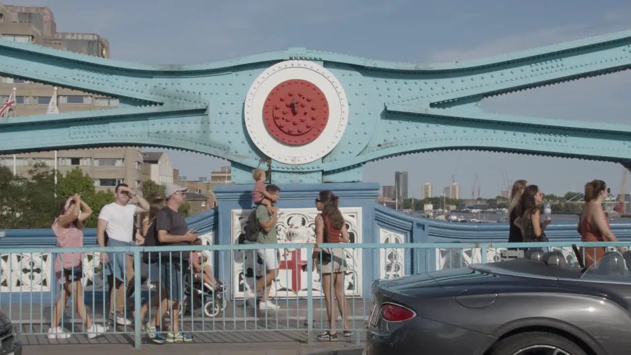 Summer Tourists Walking Across Tower Bridge London England UK With Traffic 3