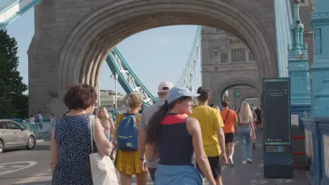 Summer Tourists Walking Across Tower Bridge London England UK With Traffic 1