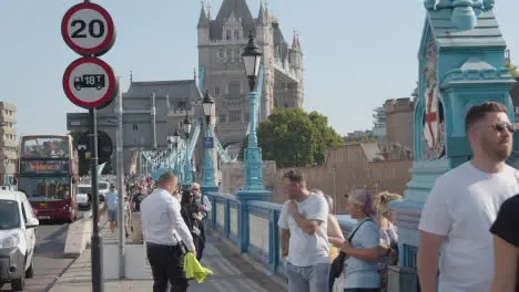 Summer Tourists Walking By Tower Bridge London England UK With Traffic