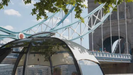 Crowd Of Summer Tourists Walking By Tower Bridge London England UK With Restaurant Pods In Foreground 1