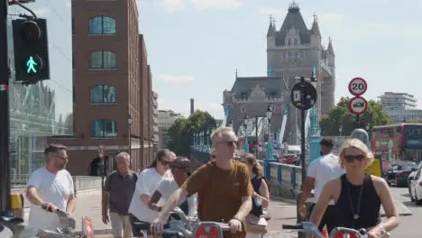 Summer Tourists Walking And Cycling By Tower Bridge London England UK With Traffic