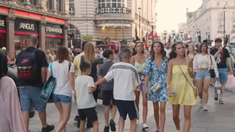 Crowd Of Summer Tourists Walking From Leicester Square Towards Piccadilly Circus In London England UK