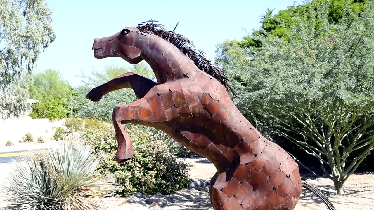 Sculpture of a large metal horse on hind legs profile view