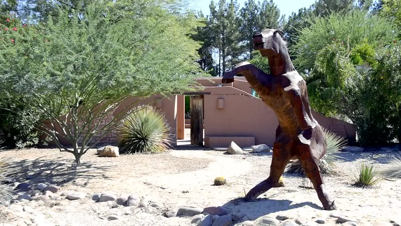 Sculpture of a large metal horse on hind legs straight on view pan left