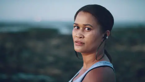 Fitness woman earphones or thinking by beach