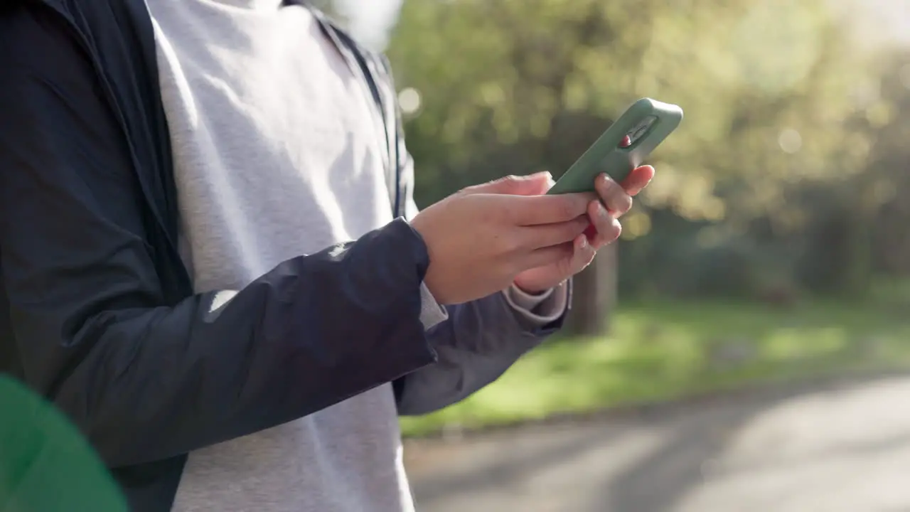 Hands smartphone and texting in park