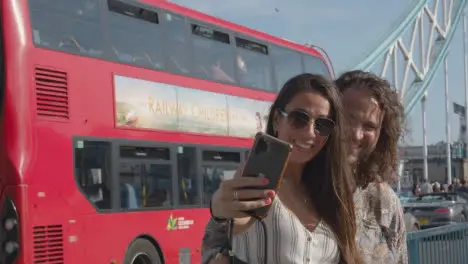 Tourist Couple Taking Selfie On Visit To Tower Bridge London England UK