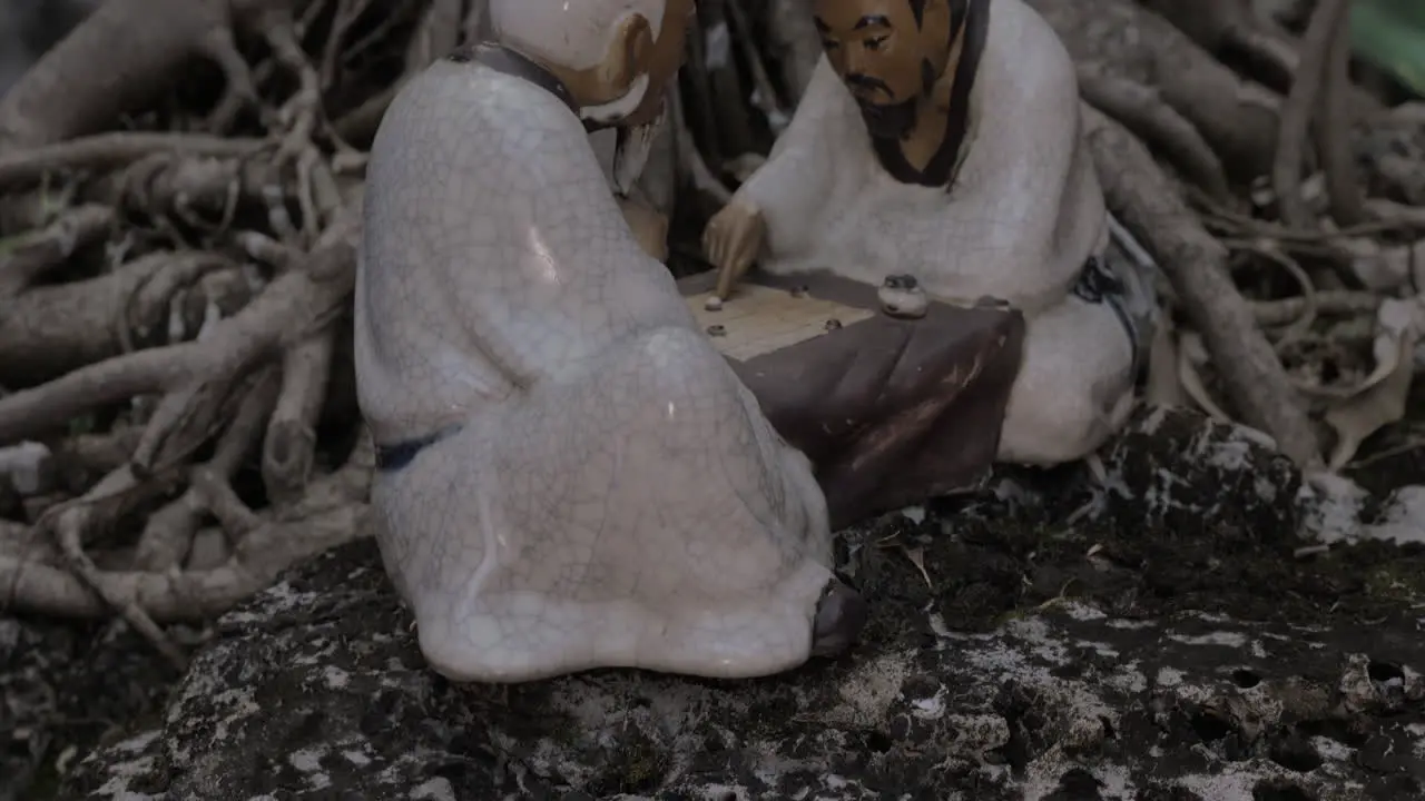 In roots of a tree in city of Hanoi Vietnam stands a porcelain figurine