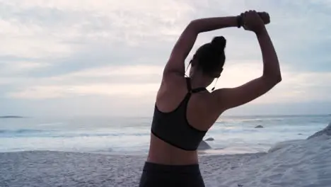 Fitness woman back or earphones in beach