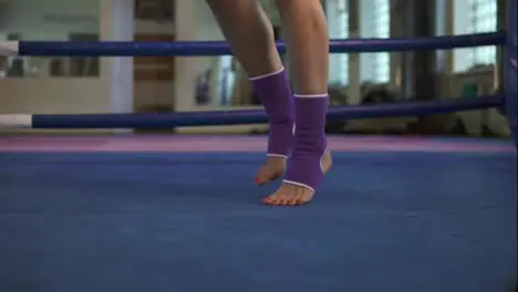 Close up view of female legs in socks jumping with skipping rope inside of the boxing ring in a fitness club Slow Motion shot